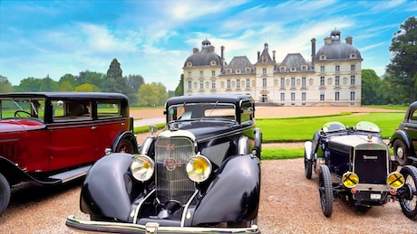 Des anciennes voitures de collection devant la façade du château de Cheverny pour le festival du chapeau
